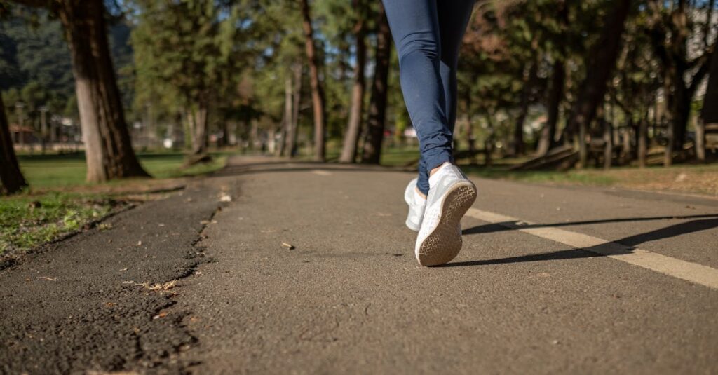 A woman jogging on a path through a park, showcasing fitness and healthy lifestyle outdoors.
